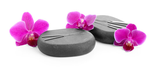 Acupuncture needles, orchid flowers and spa stones isolated on white