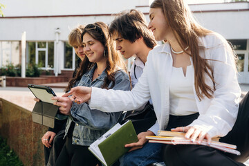 Fototapeta premium Looking at digital tablet. Group of students are near university together