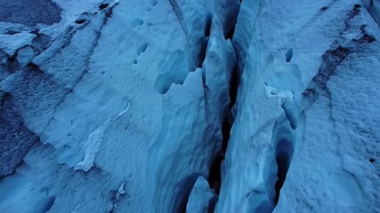 Aerial view of textured blue glacial ice with deep crevices and irregular surfaces - Powered by Adobe