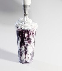 Whipped cream topping on blueberry milkshake dessert
