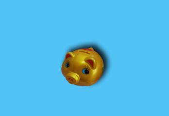 Closeup piggy bank gold color isolated on blue background for stock photo. saving concept, finance,...