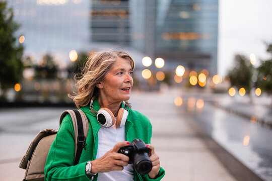 Tourist exploring city outdoors with camera and backpack