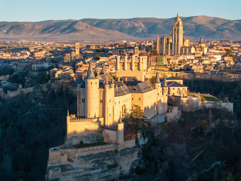 Aerial view of the Alc&Atilde;&iexcl;zar of Segovia bathed in the warm glow of the setting sun, its medieval towers contrasting with the distant cathedral spires, Segovia, Castilla y Le&Atilde;&sup3;n, Spain.