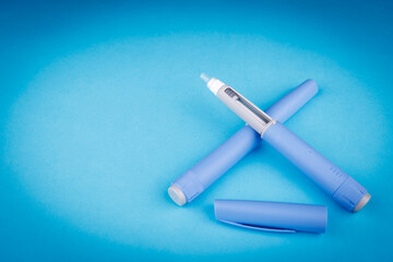 Top view of semaglutide pens on blue background, emphasizing telehealth, healthcare technology, and...