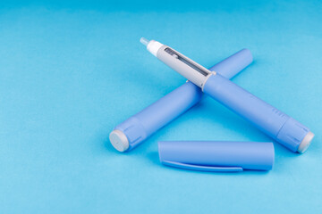 Flat lay of semaglutide pens on bright blue table, highlighting wellness, telehealth, healthy...