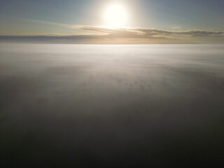 The sun rises over a misty horizon in a tranquil atmosphere, morning sun over the Hasbruch Forest...