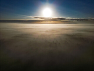 Sunlight breaks through the thick fog, creating a calming morning atmosphere. Morning sun over the...