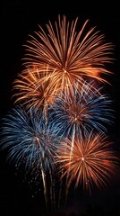 A vibrant display of fireworks lighting up the night sky with bursts of orange and blue. Perfect for celebrations and festive occasions.