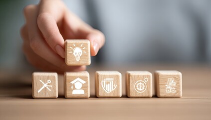 A hand places a wooden block with a lightbulb icon on top of other blocks with various icons