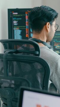 Vertical Screen : Young adult Asia male freelance eyeglasses typing write prompt AI bot app smart program nomad, video game, terminal with coding, user interface, big data center on desktop computer.