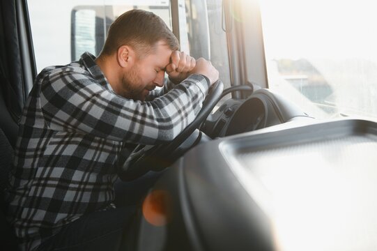 Exhausted truck driver falling asleep on steering wheel. Tiredness and sleeping concept