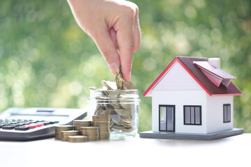 Mortgage,Model house and stack of coins money on natural green background,Business investment and...