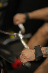 man is engaged in a block pull exercise pulling a weighted bar to his waist. He is in a gym setting...