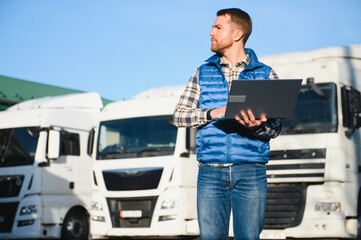 The truck driver uses a laptop to confirm the delivery of the cargo. The concept of freight transportation. Logistics