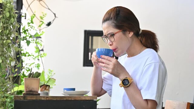 Facial expression of young Asian woman after drinking strong coffee. Strong coffee may be used to describe bitter or highly caffeinated coffee.