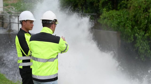 Engineer working at hydroelectric dam inspecting water release, checking gates, analyzing daily flow, monitoring water quality, ensuring maintenance, safety, sustainable energy, and environmental mana