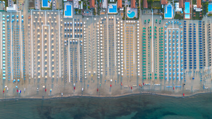 Sun umbrellas and sun loungers on the beach, Tyrrhenian Sea, tourist resort of Viareggio, Italy. View from above