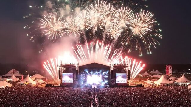 A spectacular aerial view of a grand fireworks finale over the main stage and crowd at a music festival, a magical closing ceremony.
