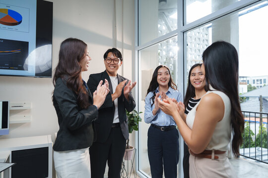 Business team clapping celebrating success in modern office