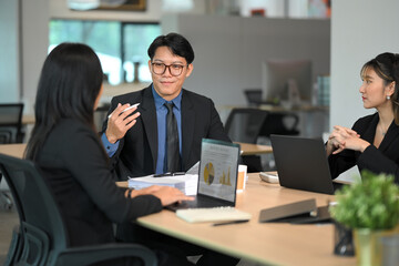 Professional colleagues discussing project details in a modern office