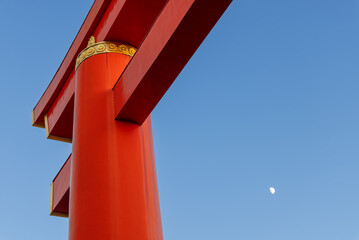Close-up view of red torii pillar with golden crest at Heian-Jingu Shrine in Kyoto, set against...