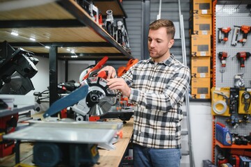 A man in a hardware store choosing a tool