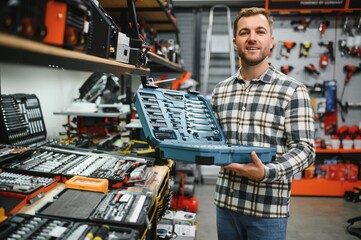 A male buyer chooses a toolbox in a hardware store. A large selection of tools.