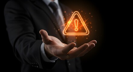 A businessman's hand presenting a glowing warning sign, symbolizing caution and risk.