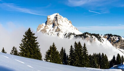 Fototapeta premium Snowy mountain peak above clouds