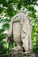 Stone urn statue with draped detail stands as a solemn memorial