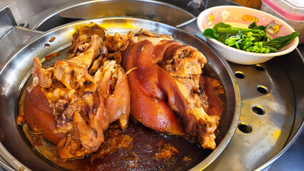Close-up of tender braised pork leg cooked in rich soy sauce stew, a traditional Asian street food dish served with rice