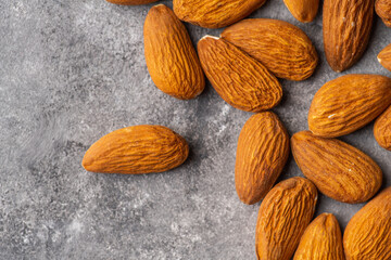 Pealed almond nuts on the gray concrete background. Healthy food. Shot from above.