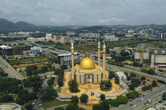 Fototapeta Aerial view of the National Mosque's golden dome gleaming amidst the urban sprawl, with the distant hills adding depth to the skyline, Abuja, Federal Capital Territory, Nigeria.