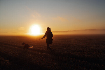 Hunter and dog in sunrise