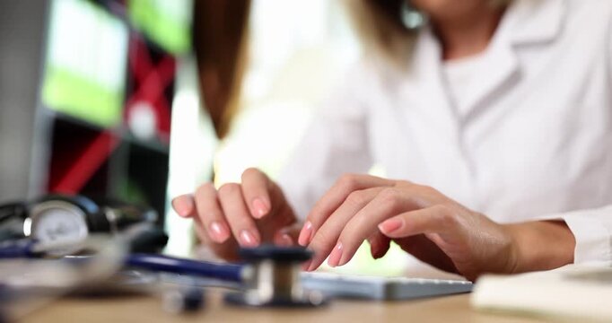 Fingers press laptop keyboard making quick tapping sounds while typing among medical tools. Woman keeps steady rhythm creating flowing text on screen