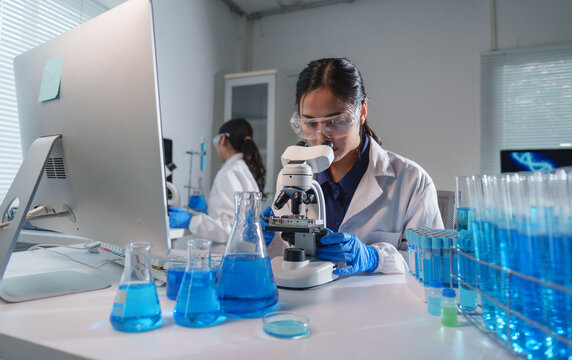 Scientist using microscope in laboratory researching new medicine