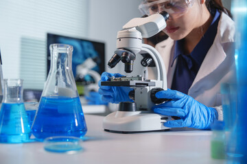 Scientist analyzing sample with microscope in laboratory