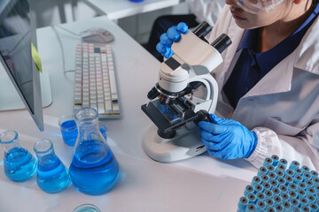 Scientist using microscope analyzing samples in laboratory research