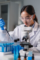 Scientist using micropipette and test tubes in laboratory research