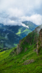 Obraz premium Misty cliffs overlooking alpine valley 