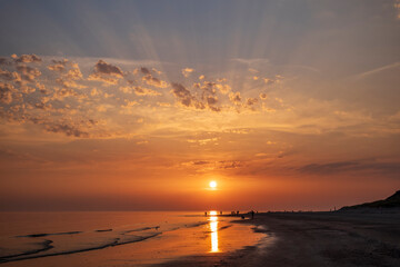 sunset on the beach with clouds and sun rays