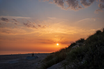 sunset on a beach with dunes