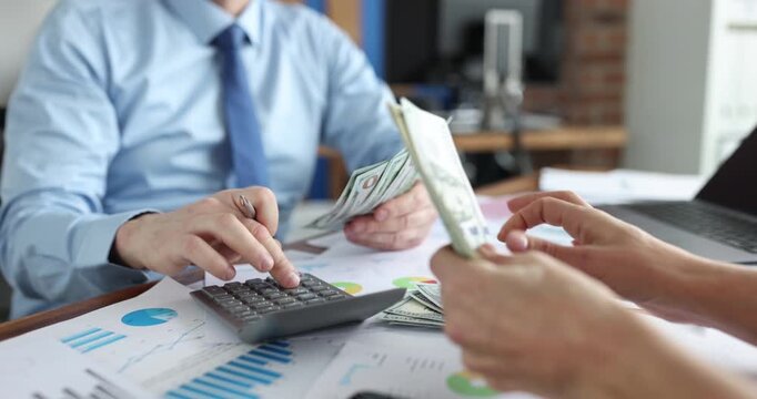 Woman counts cash sitting at table opposite man using calculator checking finance. Workers organize money stacks creating planned budget of company