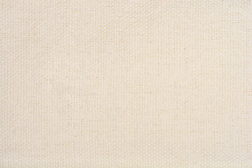 A full-frame, macro shot of a light beige, woven fabric with a visible texture