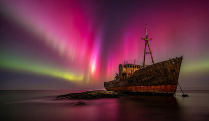 ship in the sea at night with aurora borealis 