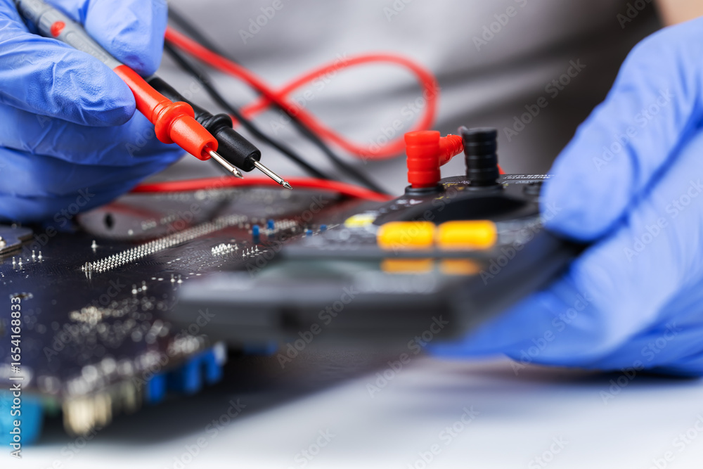 Poster technician under fixed and repairing computer mainboard process by used multimeter