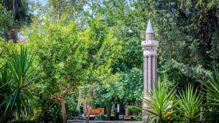 Historical column in a lush green park.
