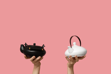 Woman with teapots on pink background
