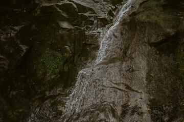 waterfall  in the forest leading into the Bregenzer Ache  in Vorarlberg Austria in brown colours 