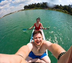 Couple Paddleboarding on a Sunny Lake